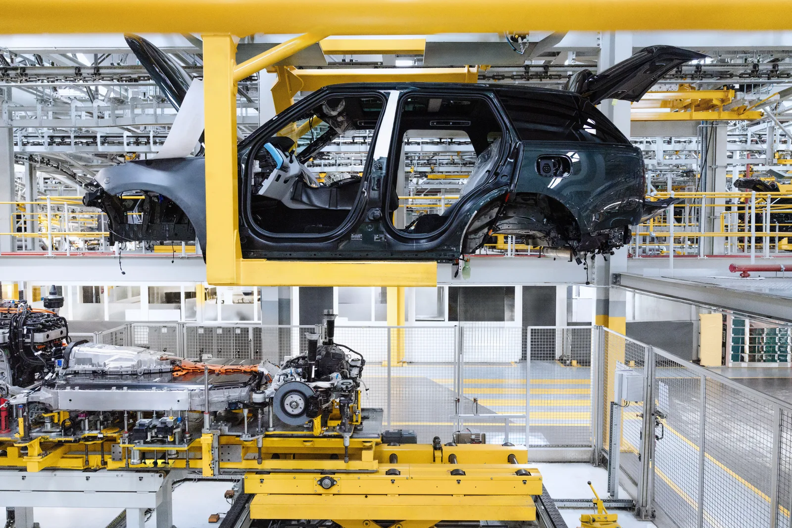 A Range Rover Electric body shell on the production line at JLR's Solihull plant, with a battery pack on the floor below